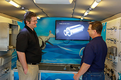 Vinny Calabrese, Process Automation Business Development, left, introduces Marcus Sweitzer, PennAir Technical Sales Professional, to the range of Festo products in the company’s truck-based mobile lab.