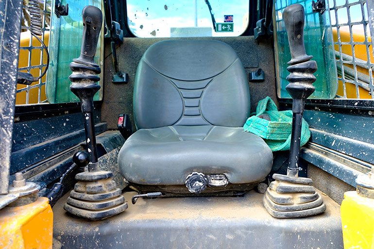 Figure 1. Older cabs were often small and crammed with valves and joysticks.