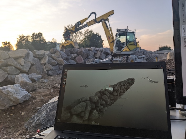 Autonomous hydraulic excavator building a stone wall.