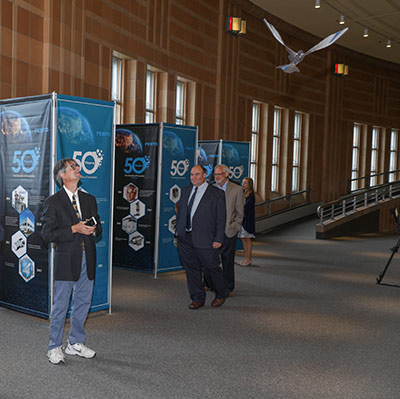 A guest at the Festo 50th Anniversary Gala marvels at the lifelike flight of the Festo Bionic Swift.