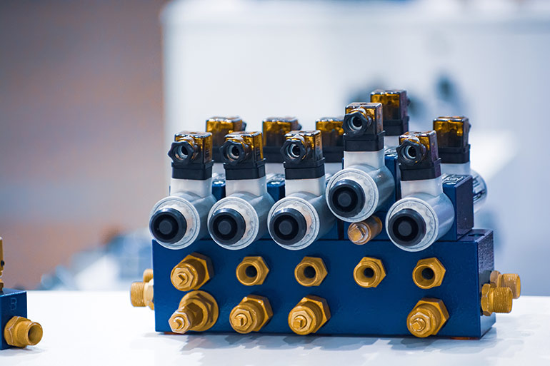 Figure 3. Solenoid valves on a hydraulic bar manifold.Image Adobe Stock