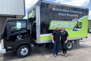 Hoses2U owners John and Alison Abercrombie standing in front of a Hoses2U truck.