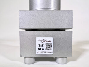 A Milwaukee Cylinder electronic service tag QR code on the surface of a hydraulic cylinder.