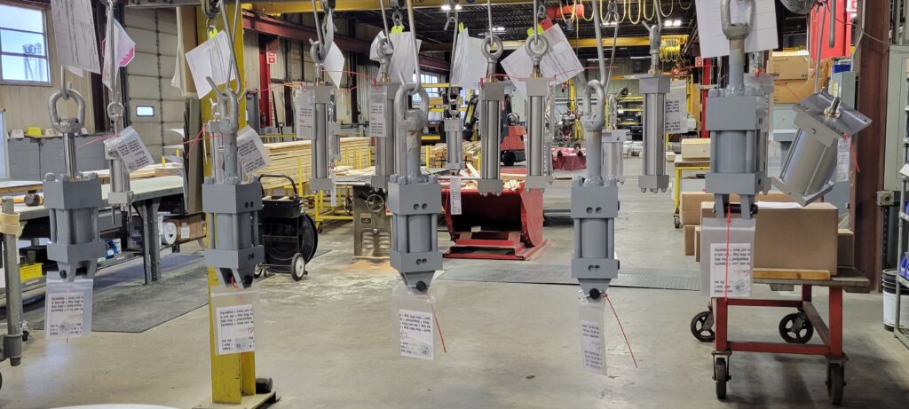 Hydraulic cylinders with Milwaukee Cylinder Electronic Service Tags hanging and ready to ship.