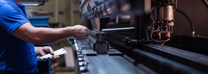 A technician works on a hydraulic press. Image Source: FreeImages